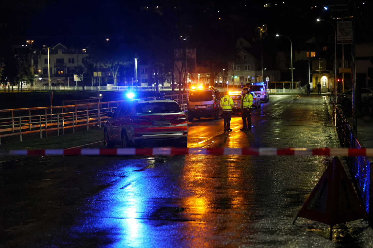 Police vehicles and officers behind cordon tape at night near the Schachen area of Aarau